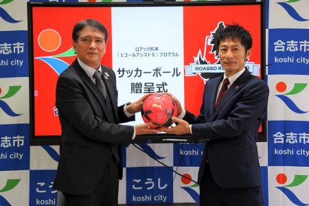 サッカーボールを持つ中島教育長と株式会社アスリートクラブ熊本の古賀部長。