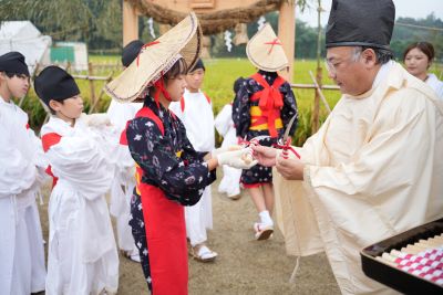 神職から鎌を渡されるこどもたちの様子です。