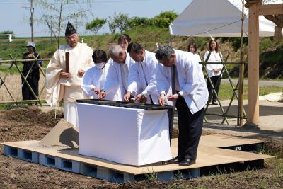 播種祭で稲の種を苗床にまく関係者の様子です。