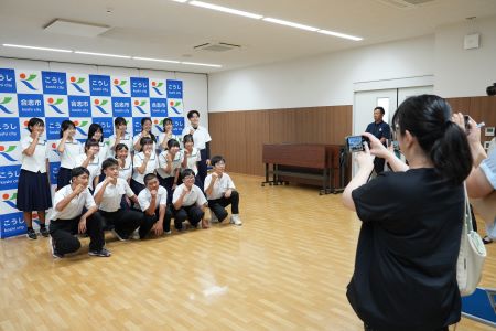 合志市のパネルを前に記念撮影