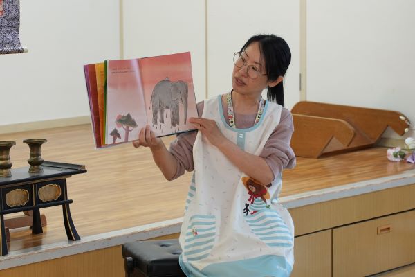 絵本を読み聞かせする保育士