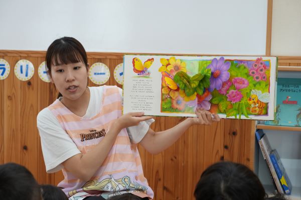 絵本を読み聞かせする保育士