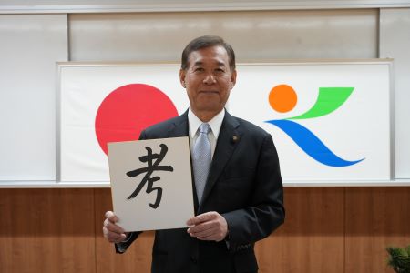 今年の一字『考』をしたためた色紙を持つ荒木市長